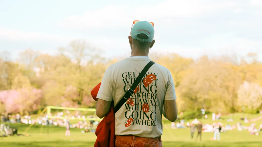 Man at a music festival looking towards a crown of people.