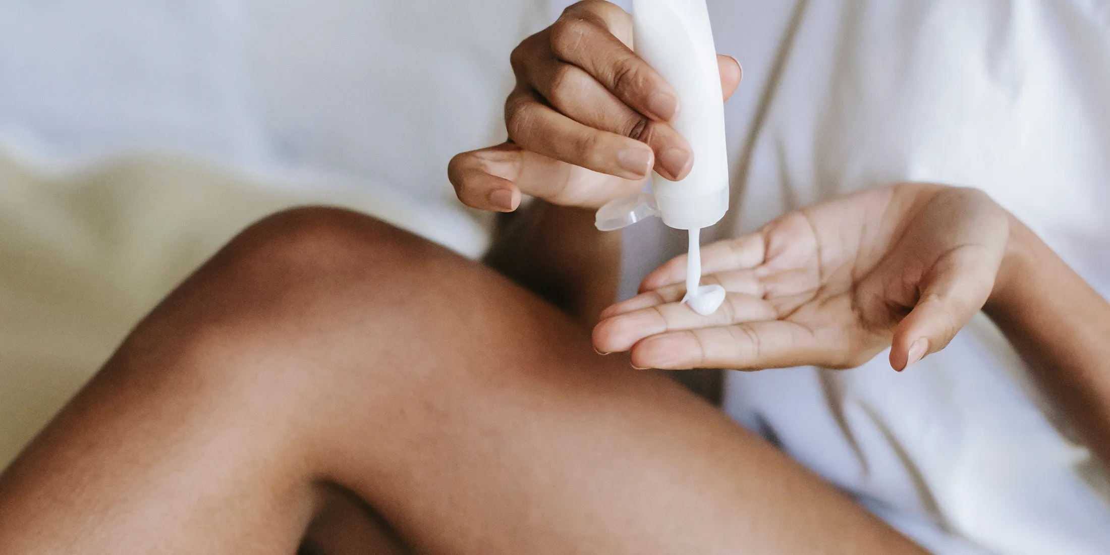 Woman applying THC lotion to her leg.