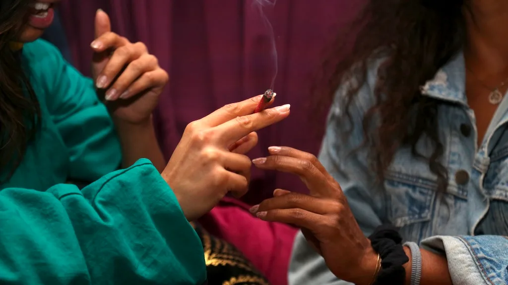 Two women sharing a pre-roll.