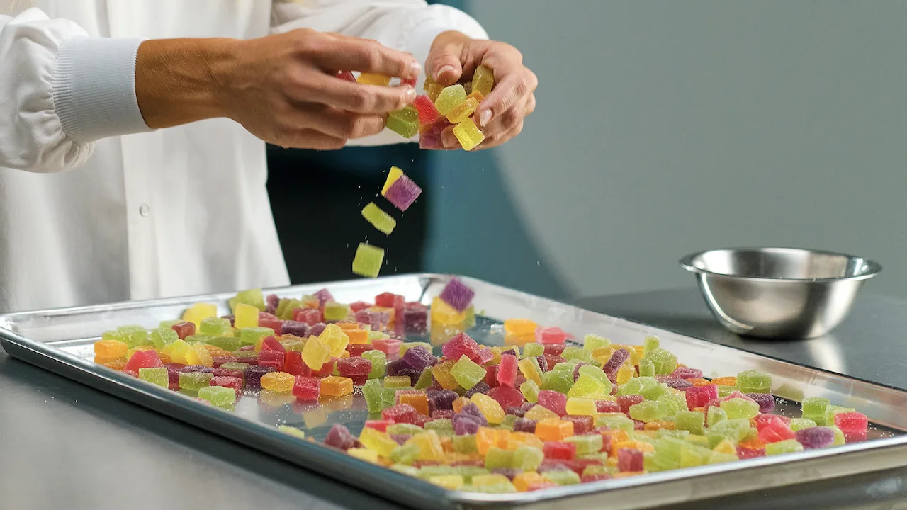 Chef arranging cannabis gummies on a baking sheet.