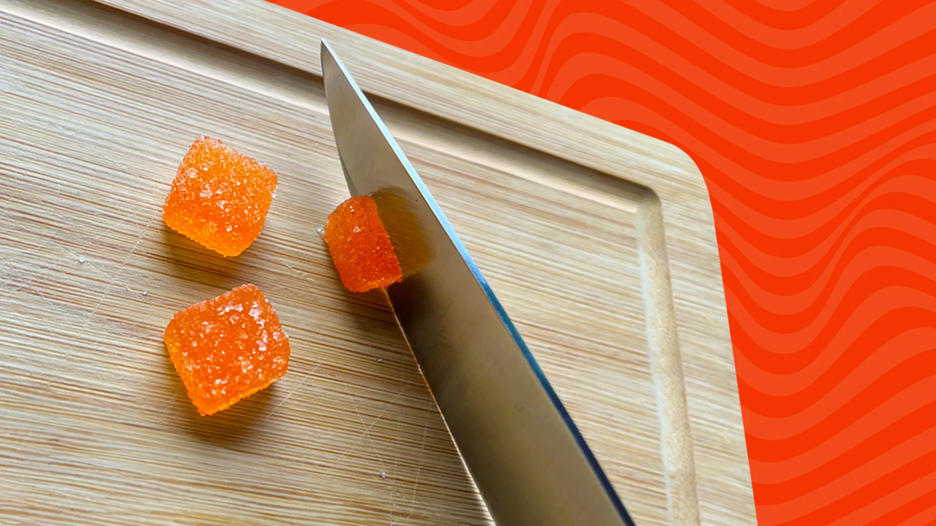 knife cutting gummies in half on a chalkboard