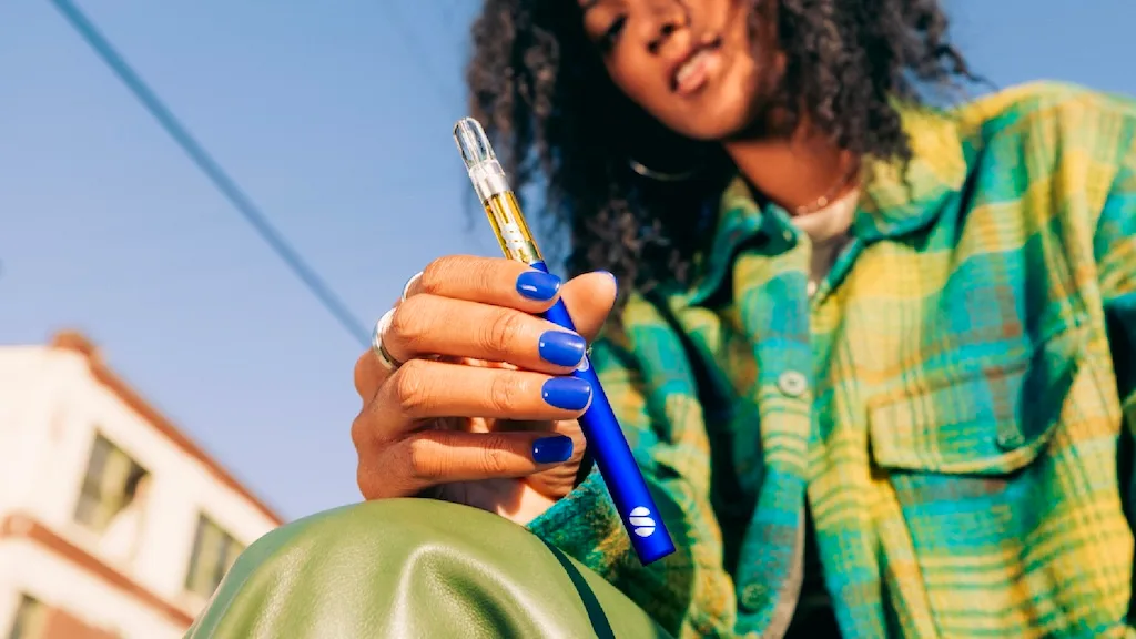 Woman holding a vape from Select.