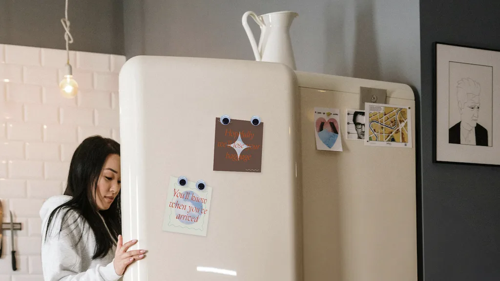 Woman storing cannabis in a white refrigerator.