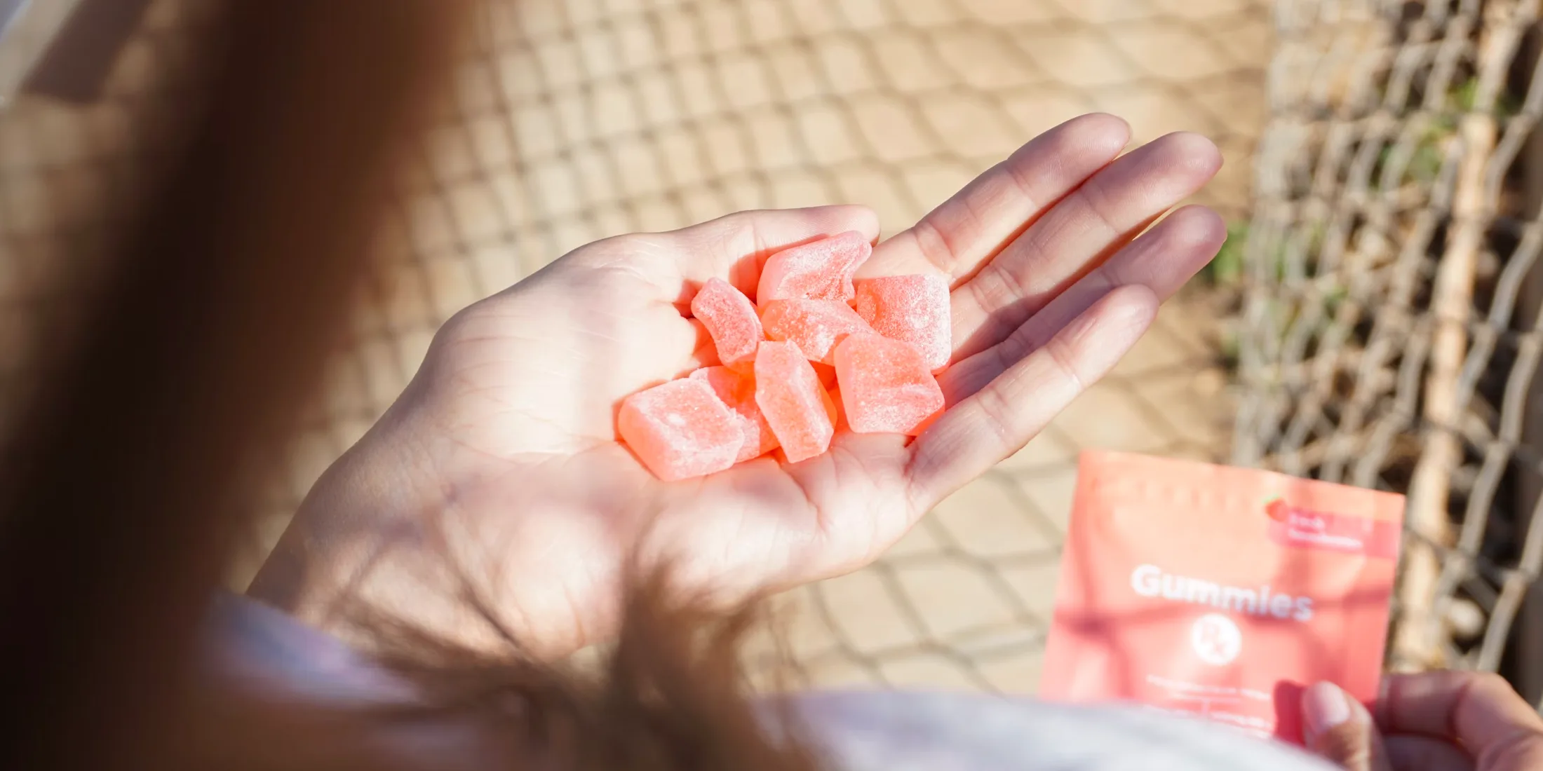 Woman holding cannabis gummies in her hand.