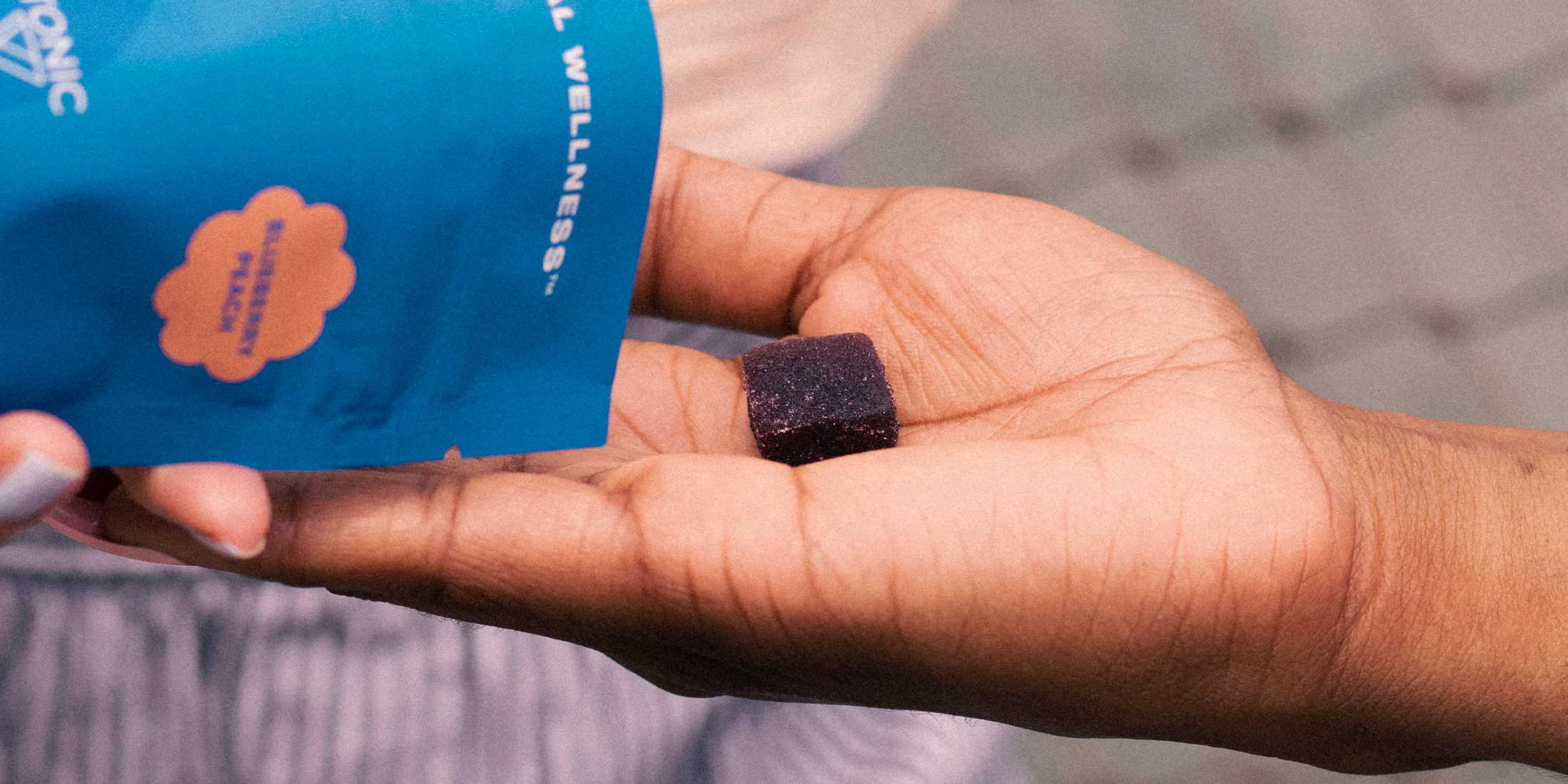 Pouring weed gummies onto hand from package.