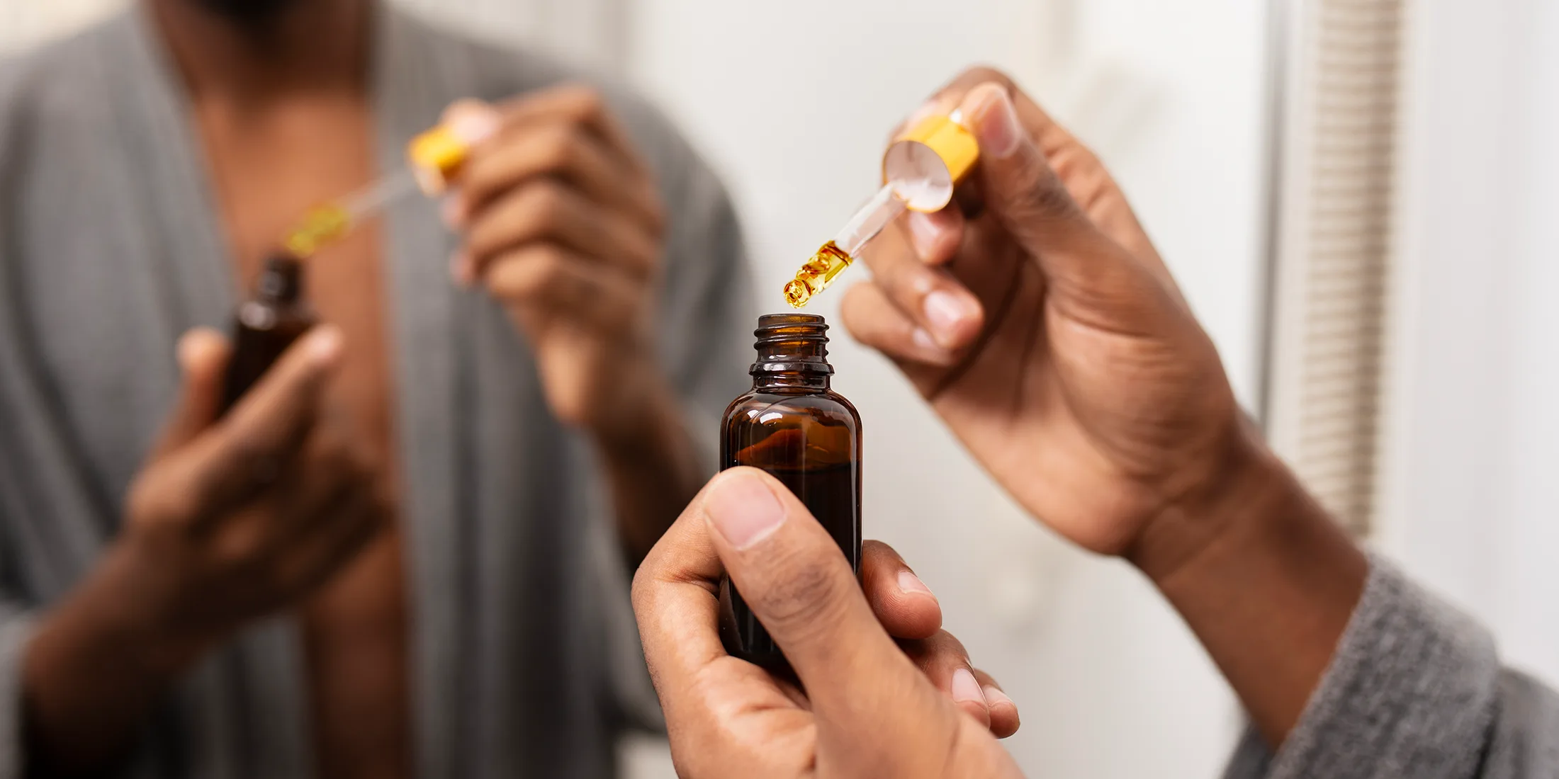 Woman taking a 'dose' from a THC dropper bottle.
