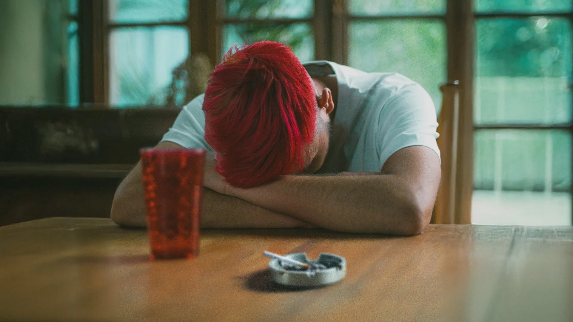 Man sitting at a table with his head down.
