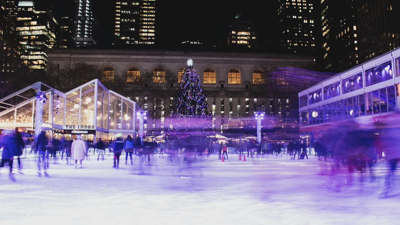 An ice skating rink and people skating in NYC.